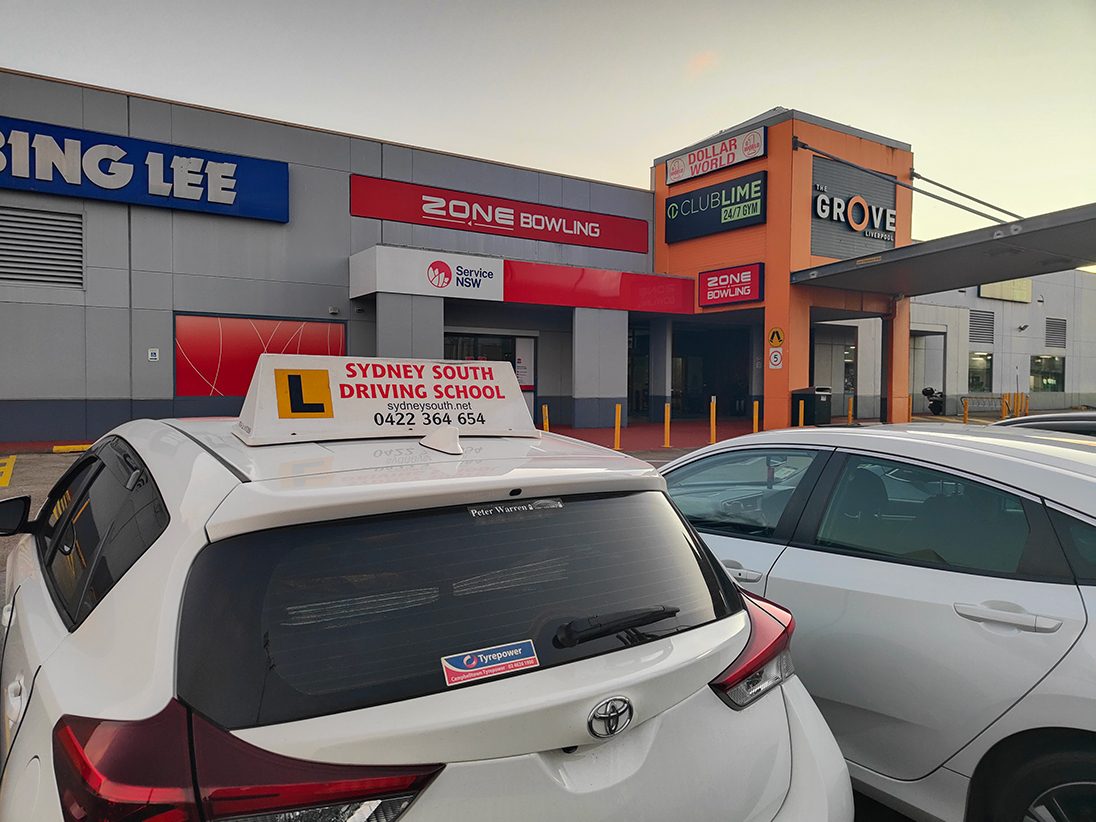 A Sydney South Driving School car parked outside the Service NSW centre at The Grove, Liverpool